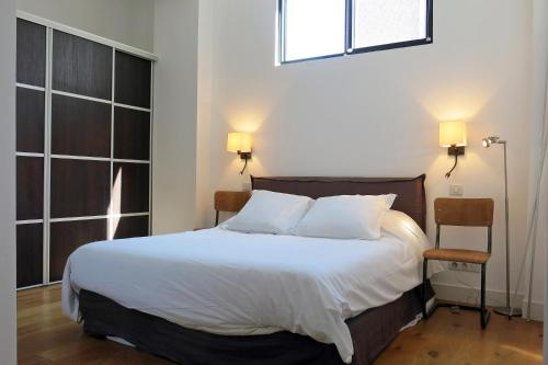a bedroom with a bed with two pillows and a window at Loft Vinaigriers République in Paris