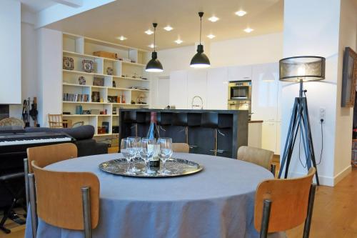 - une table avec des verres à vin dans le salon dans l'établissement Loft Vinaigriers République, à Paris