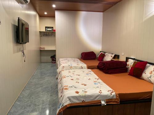 ein Zimmer mit zwei Betten und einem Flachbildfernseher in der Unterkunft Mộc Homestay - Mộc Châu in Mộc Châu