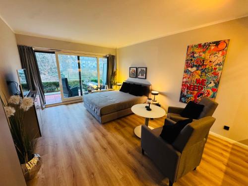 een slaapkamer met een bed, een bank en een tafel bij Bellevue Nr 13 in Scharbeutz