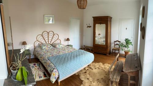 una camera da letto con un letto, un comò e uno specchio di Chez Mathé Longère Charentaise a Cercoux