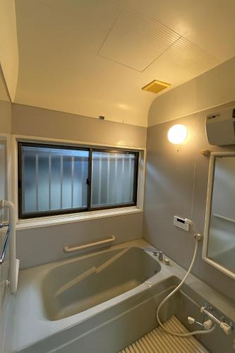 a bath tub in a bathroom with a window at One Room in Pusang Gala in Yuki