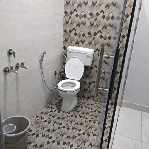 a bathroom with a toilet in a shower stall at nyagaon swimming pool in Malaut