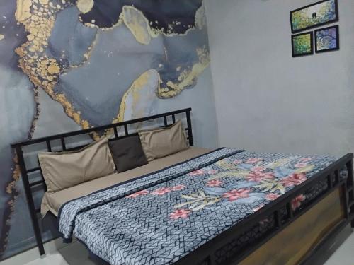 a bed in a room with a painting on the wall at nyagaon swimming pool in Malaut