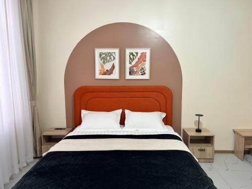 ein Schlafzimmer mit einem großen Bett mit einem Bogen darüber in der Unterkunft Bekarys Hotel in Astana