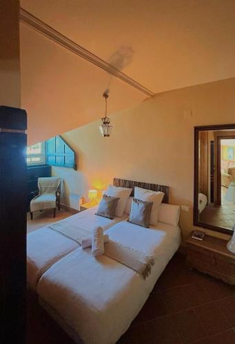 a large white bed in a room with a mirror at Plaza Andalucía Edificio Enebro 4-6 pax in Sierra Nevada