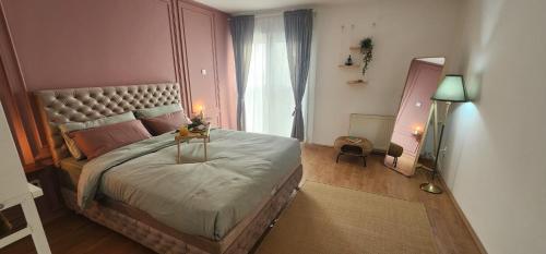 een slaapkamer met een groot bed en een raam bij Apartman Mia in Čačak