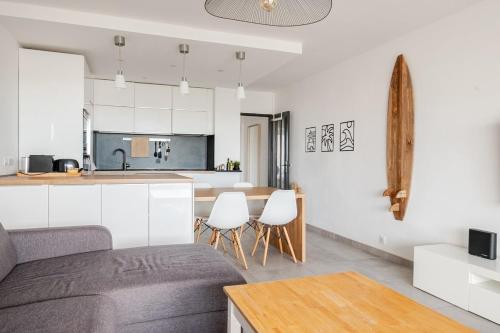 a kitchen and living room with a couch and a table at Le Plein Sud in Le Grau-du-Roi