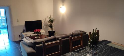 un soggiorno con un divano e un tavolo di Gîte L'hôtellerie a Trévron