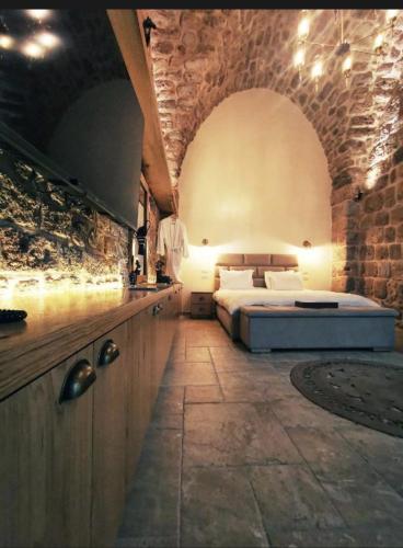 a bedroom with a bed and a stone wall at Akotika boutique in Acre