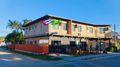 a building with flags on the side of it at Pousada Horizontes do Rosa in Praia do Rosa