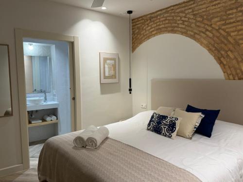 ein Schlafzimmer mit einem großen Bett mit Ziegelwand in der Unterkunft Arcos de Santa Marta in Córdoba