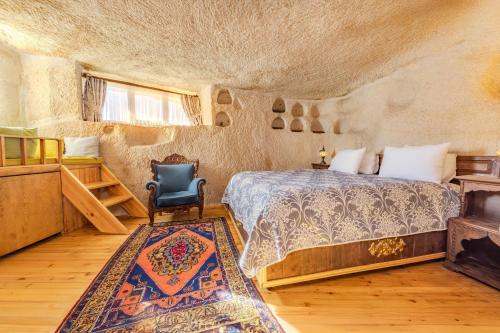 een slaapkamer met een bed, een stoel en een tapijt bij Ascension Cave Suites - Special Class in Goreme