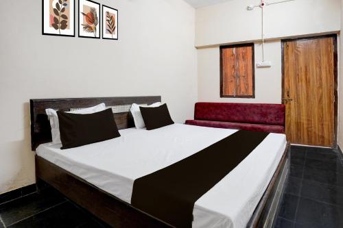 um quarto com uma cama grande e um sofá vermelho em Hotel O by OYO RASRANG em Raipur