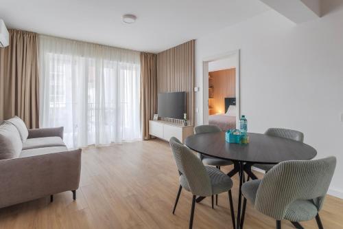 a living room with a table and chairs and a couch at Velour Suites in Oradea