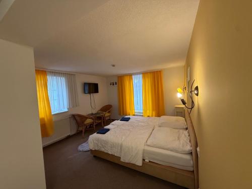 een slaapkamer met een groot bed en gele gordijnen bij Leos und Armando Gjuci GbR in Großpostwitz