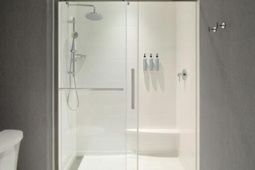 een douche met een glazen deur in een badkamer bij Residence Inn by Marriott Bromont in Bromont