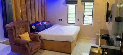 a small bedroom with a bed and a chair at 517 VIP suites and apartments in Awka