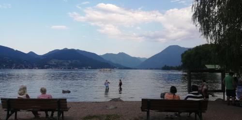 Een groep mensen zit op bankjes en kijkt naar mensen in het water. bij Seeloft in Gmunden