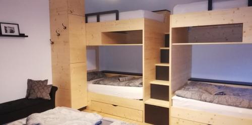 een kamer met 2 stapelbedden en een bank bij Seeloft in Gmunden