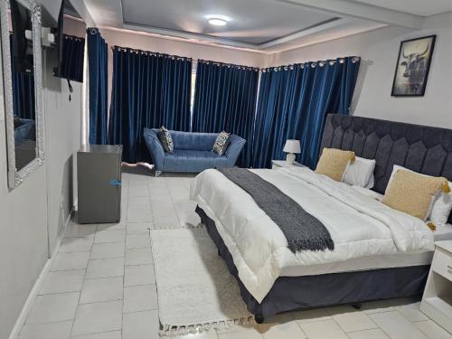 a bedroom with a large bed and a couch at Phozi Inn in Eshowe
