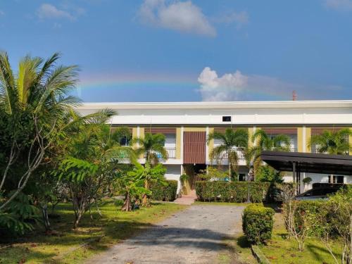 a building with palm trees in front of it at Bangtao Mango House in Bang Tao Beach