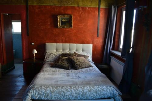 een slaapkamer met een groot bed met een oranje muur bij La Dimora della Luna Appartamento Rosso in Trieste