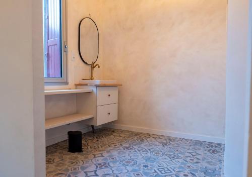 bagno con tavolo da trucco e specchio a parete. di Chez Jojo a Port-Vendres