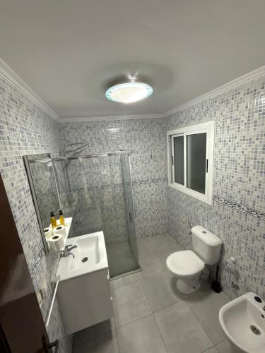 a bathroom with a shower and a toilet and a sink at My home in Tétouan