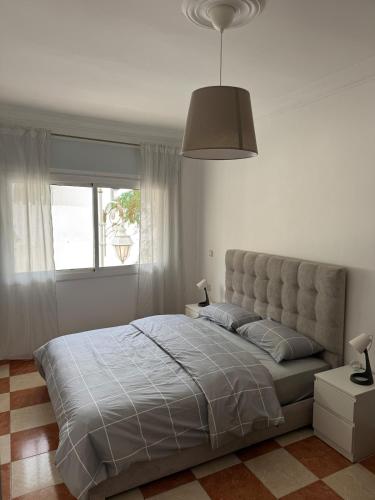 a bedroom with a large bed and a window at My home in Tétouan