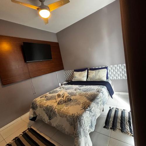 ein Schlafzimmer mit Bett und Flachbildfernseher in der Unterkunft Casa do Rocco in Cabo Frio
