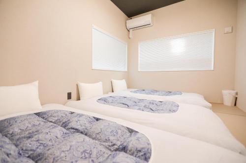 two beds in a room with two windows at 朱鷺ノ清102 in Odawara