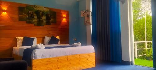 een slaapkamer met een bed en een groot raam bij Off grid Ella Homestay in Ella