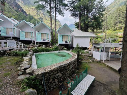 een huis met een golfbaan in de tuin bij Teji's Riverside Cottages in Kasol