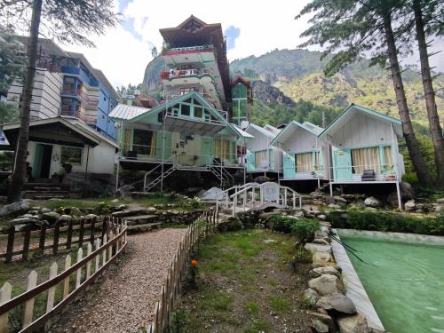 een huis met een trein bovenop een berg bij Teji's Riverside Cottages in Kasol