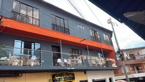 a building with tables and chairs on a balcony at Hotel y Restaurante More in Supía