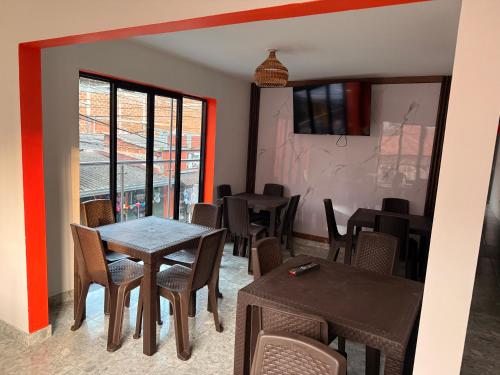 a dining room with tables and chairs and a window at Hotel y Restaurante More in Supía