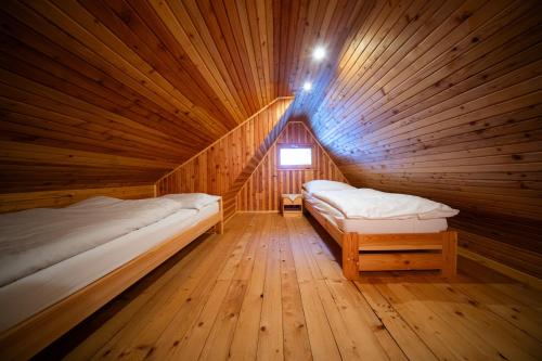 a wooden cabin with two beds in a room at Chalupa SKI Jezersko in Vígľaš