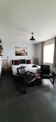 a living room with a bed and two chairs at B & B Victors Hof, met zwemvijver en leuke diertjes in Lievegem