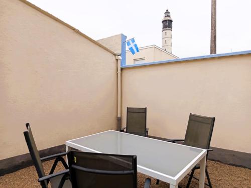 a white table and chairs with a lighthouse in the background at The Calais Beacon in Calais