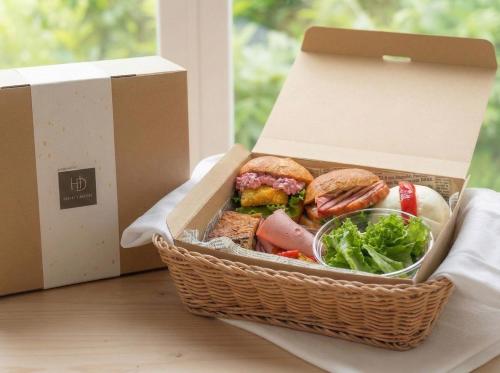 un cesto pieno di cibo appoggiato accanto a una finestra di Tsuyukusa-an a Kyoto