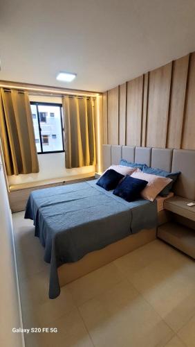 a bedroom with a large bed and a window at Luxo e Requinte em um só lugar! in Maceió