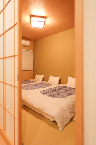two beds in a small room with a window at 朱鷺ノ清101 in Odawara