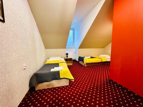 Zimmer mit 2 Betten und rotem Boden in der Unterkunft Zajazd Piękna Góra in Goldap