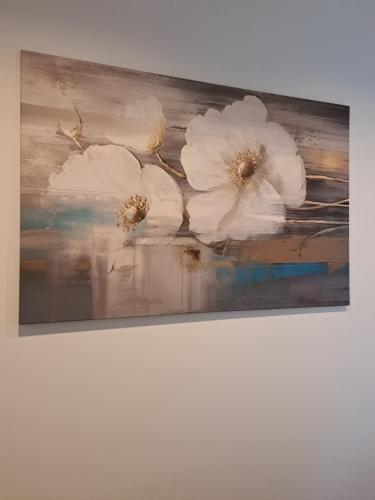 un dipinto di fiori bianchi su un muro di CanvasHome Apartamenty a Katowice