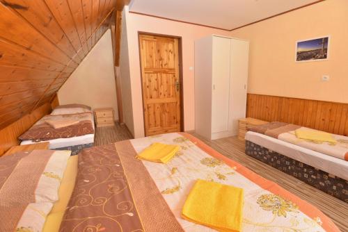 a bedroom with two beds and a wooden floor at Penzion Jizerka in Jablonec nad Nisou