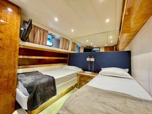 een slaapkamer met twee bedden en een bureau in een boot bij Mimou Accommodation breakfast on yacht in Yasmine