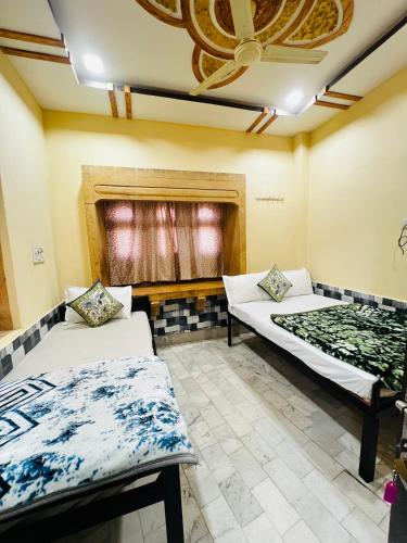 een kamer met twee bedden en een raam bij Hostel Desert Routes in Jaisalmer