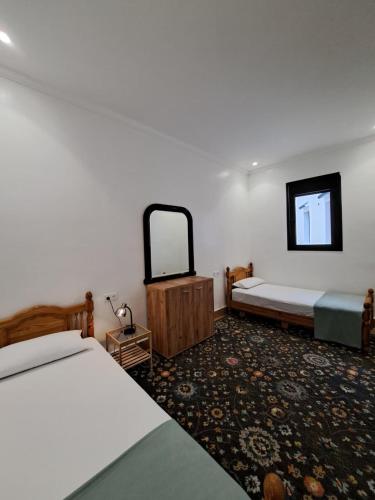 a hotel room with two beds and a mirror at Central Tangier , 3xBedroom , Apartment, Historic Medina, Margarita in Tangier