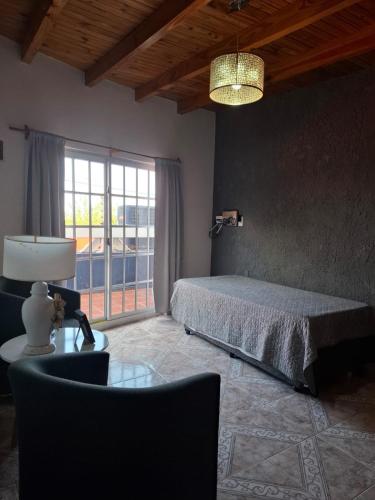 een slaapkamer met een bed en een tafel met een lamp bij Vista Malbec 1 in Ciudad Lujan de Cuyo